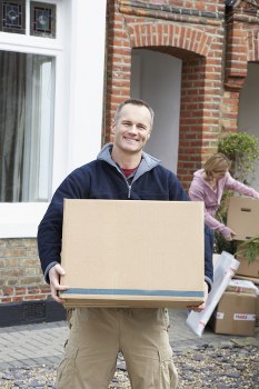 Removal team member carrying a boxed item with safety awareness