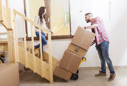 Professional movers handling furniture in a compact central London property